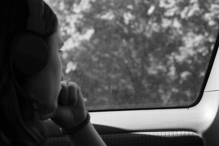 Breaking the Cycle of Addiction: A monochrome image of someone looking sadly out of a car window, possibly considering how to break the cycle of addiction.