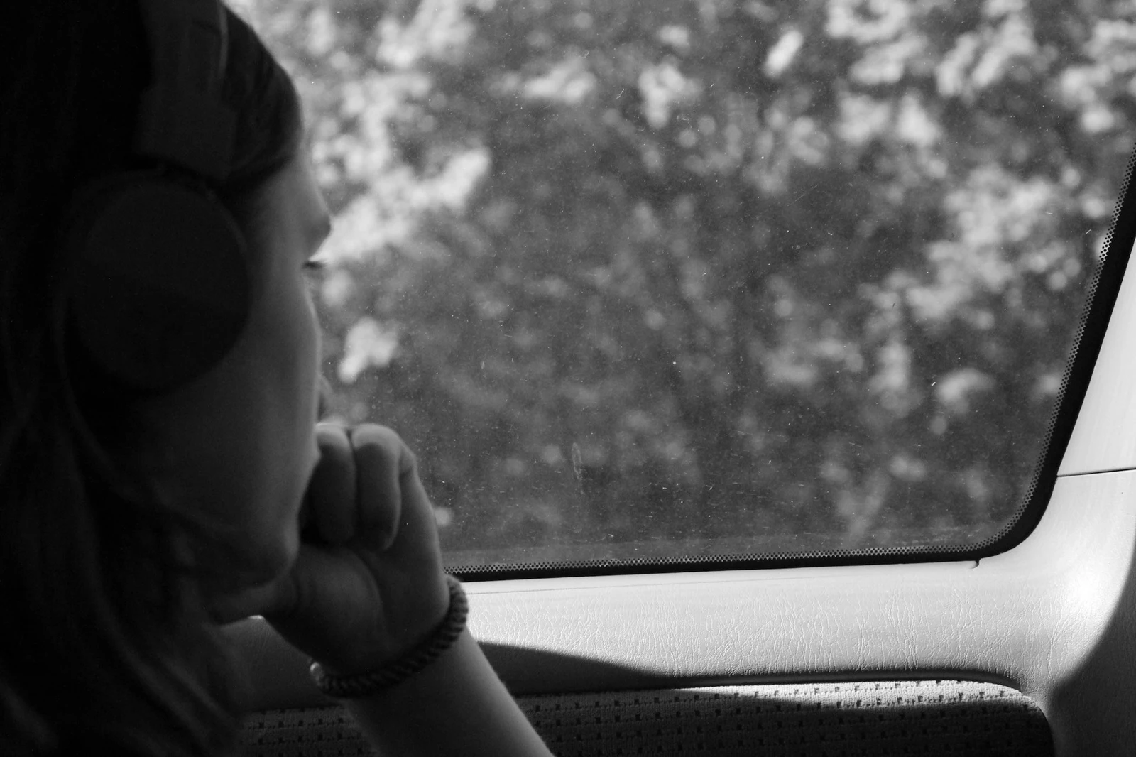 Breaking the Cycle of Addiction: A monochrome image of someone looking sadly out of a car window, possibly considering how to break the cycle of addiction.