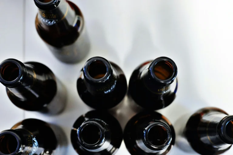 Empty beer bottles seen from above against a white background show the bleakness associated with alcohol use disorder, often treated with Antabuse generic name alternatives.