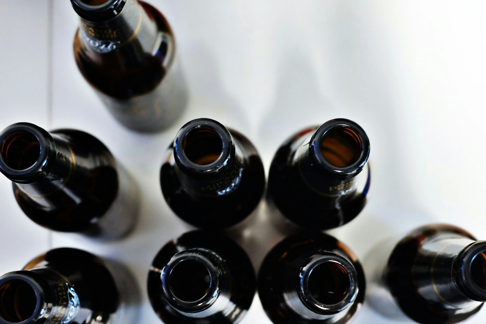 Empty beer bottles seen from above against a white background show the bleakness associated with alcohol use disorder, often treated with Antabuse generic name alternatives.