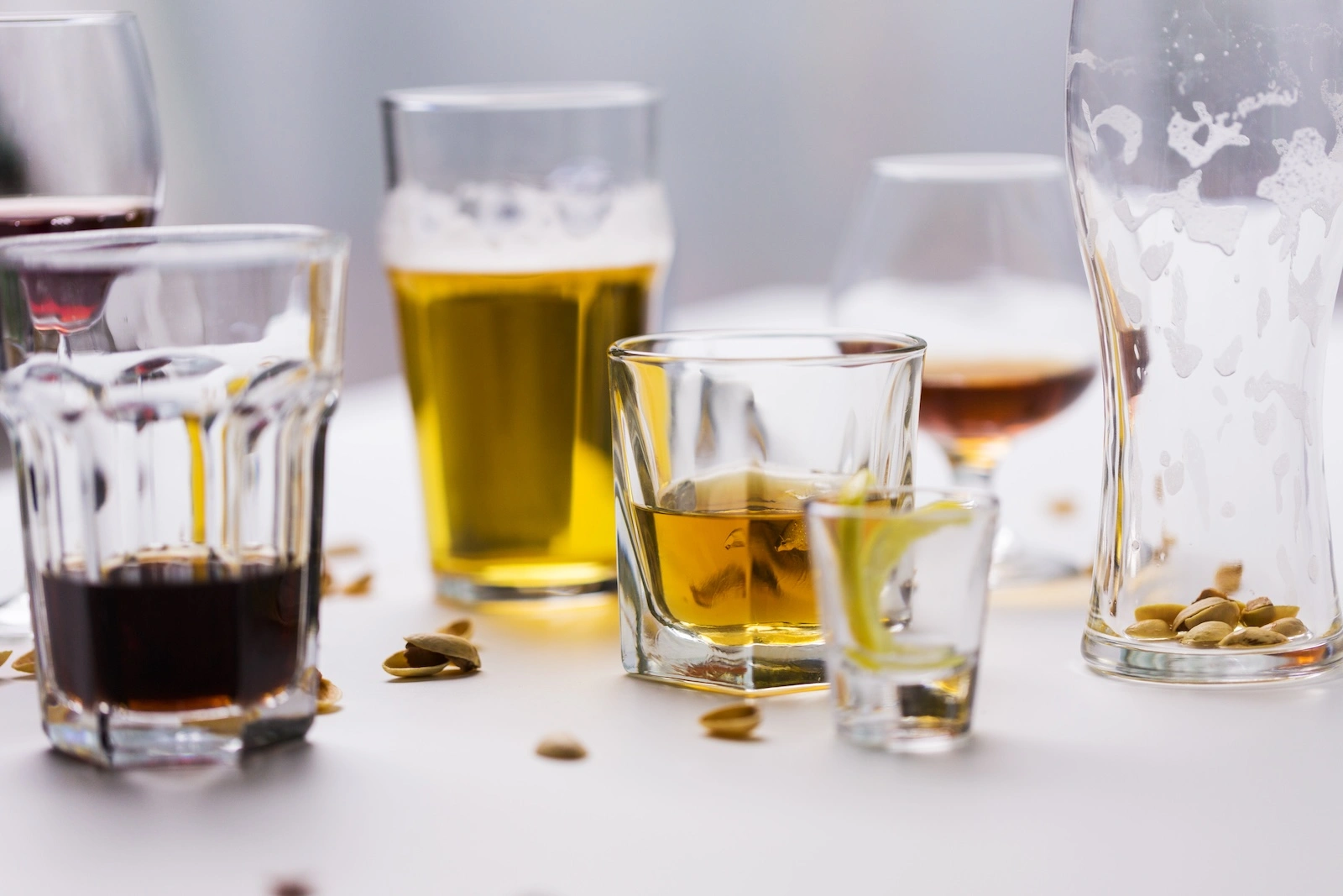 an assortment of glasses with varying levels of alcohol in them on a table top