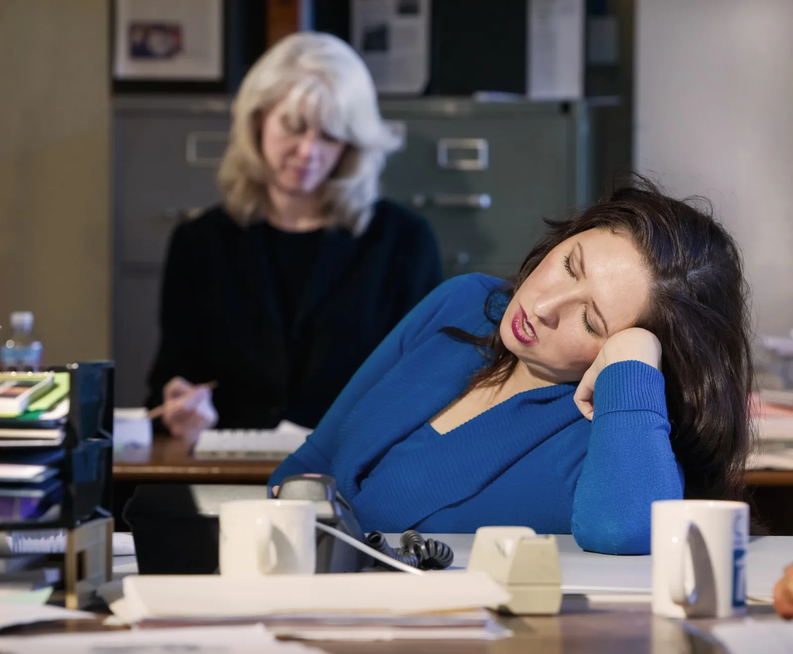 A woman falls asleep at her desk as clonidine withdrawal causes drowsiness